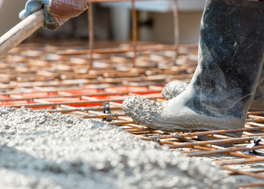 Worker pouring concrete mix at home foundation